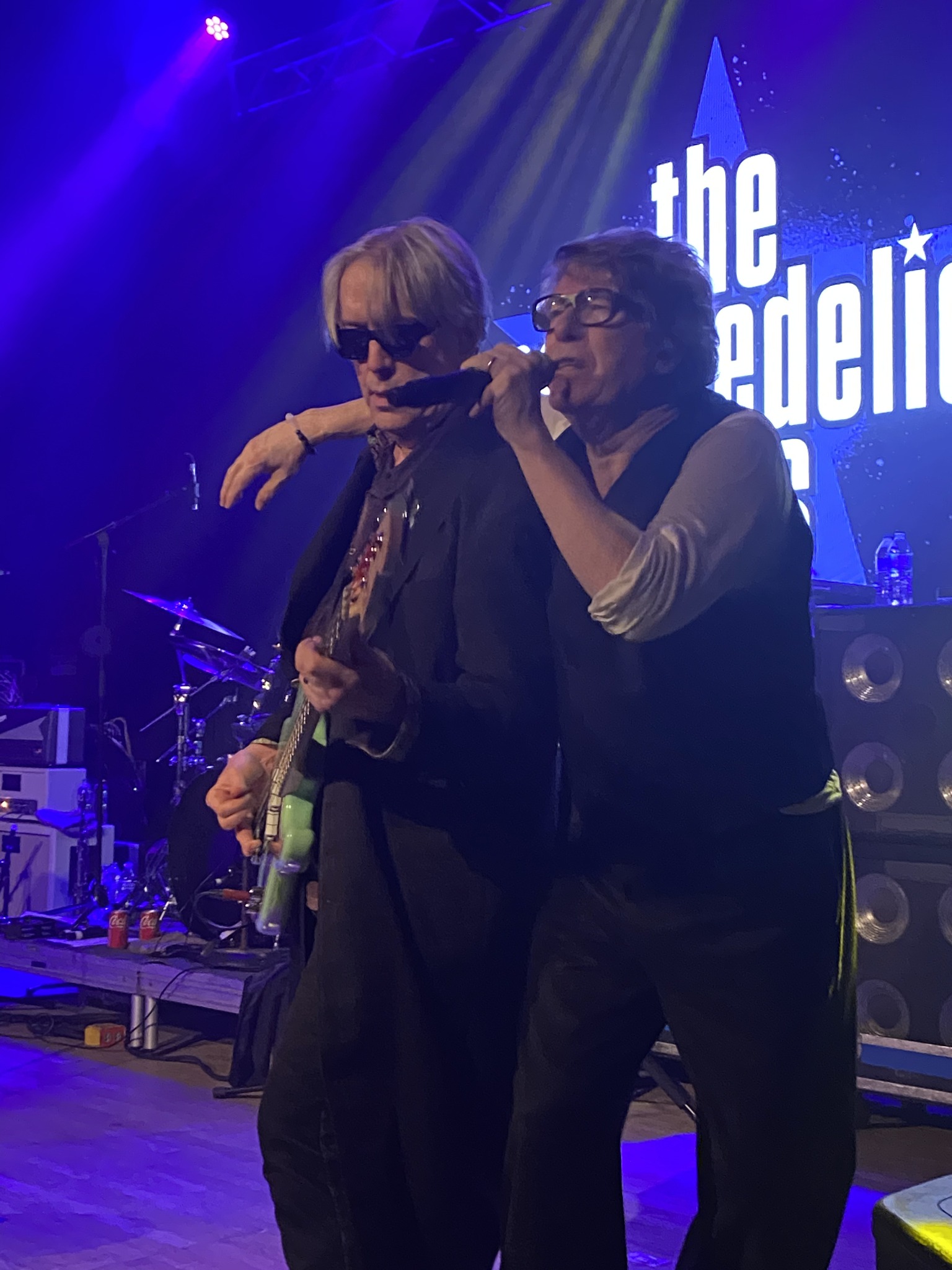 Members of The Psychedelic Furs performing under blue stage lights
